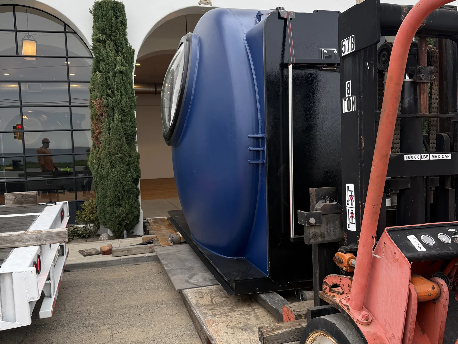 Forklift positioning a large vacuum chamber for unloading
