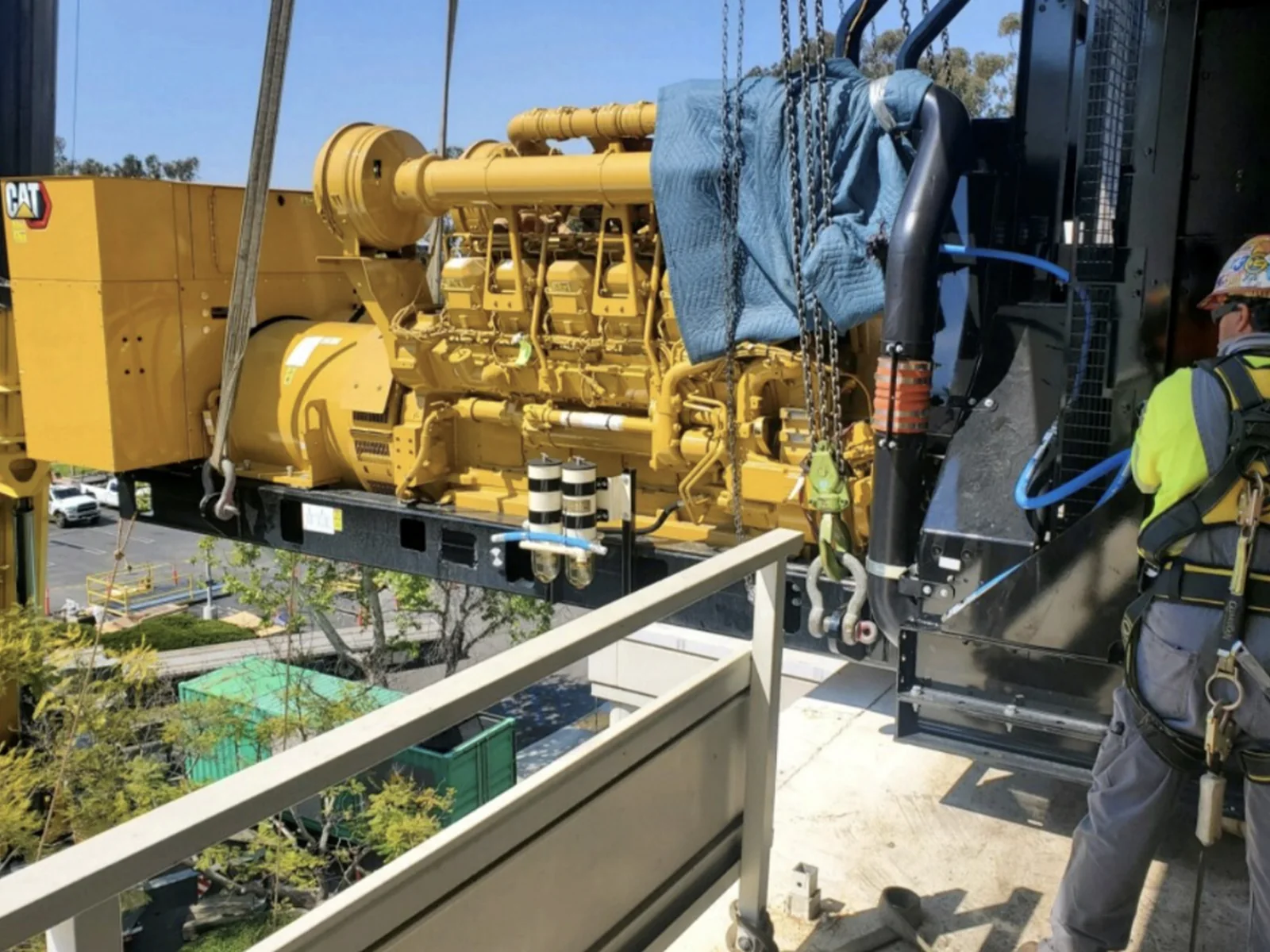 Crew rigging a generator for placement at an elevated equipment area