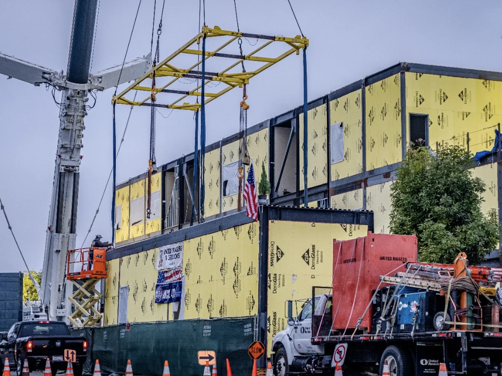 Crew connecting a steel frame between modular building sections