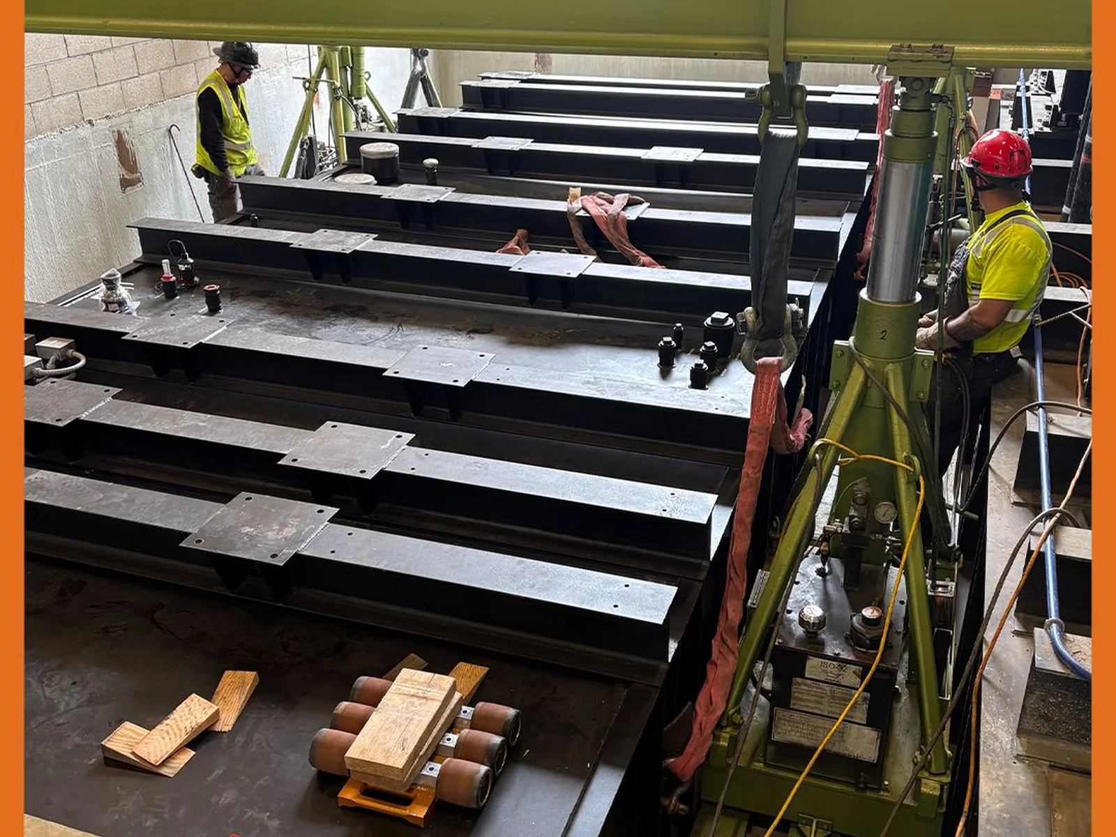 Steel equipment support frames positioned beneath a hydraulic gantry