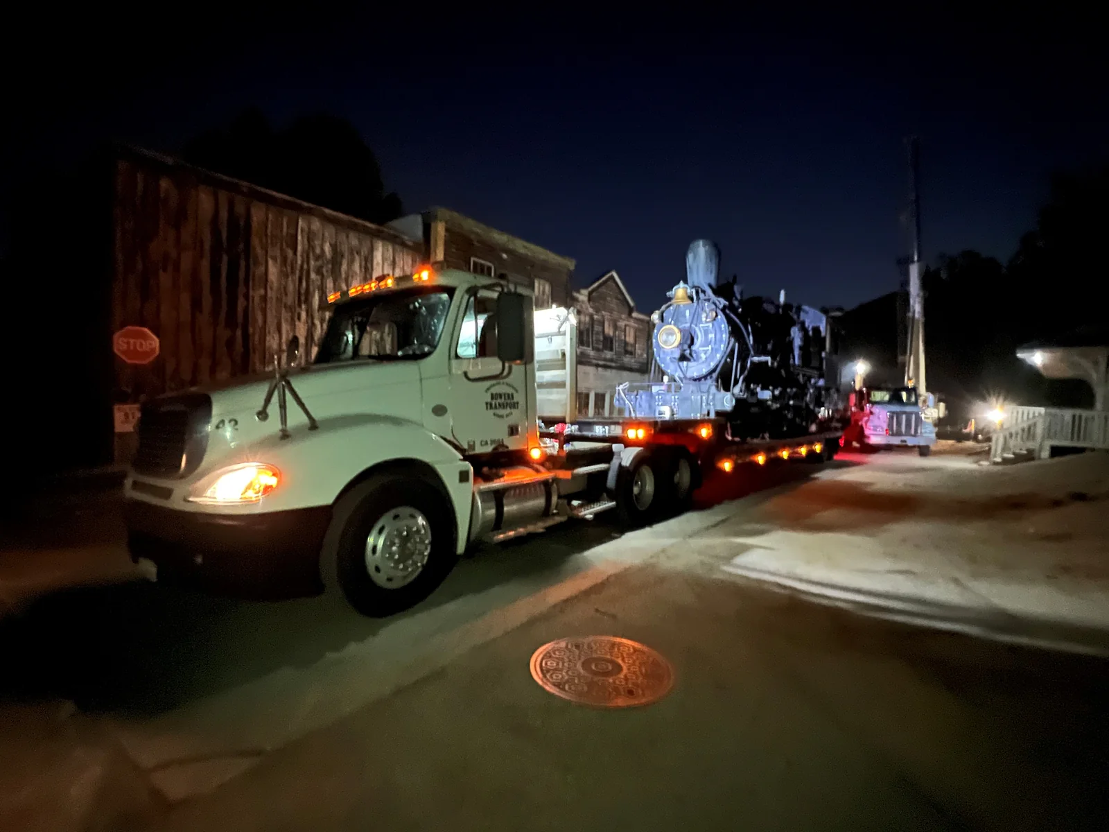 Historic locomotive transported at night on a specialized trailer