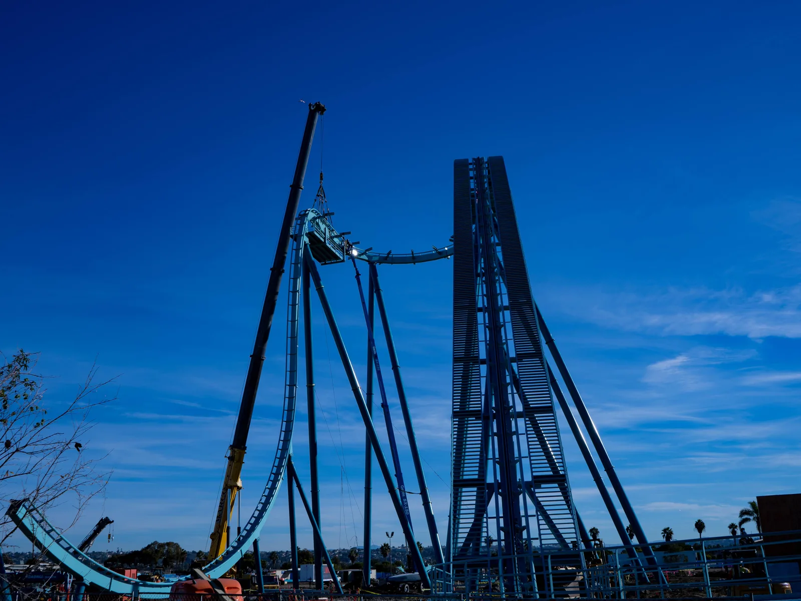 Crane installing an elevated steel roller-coaster track section